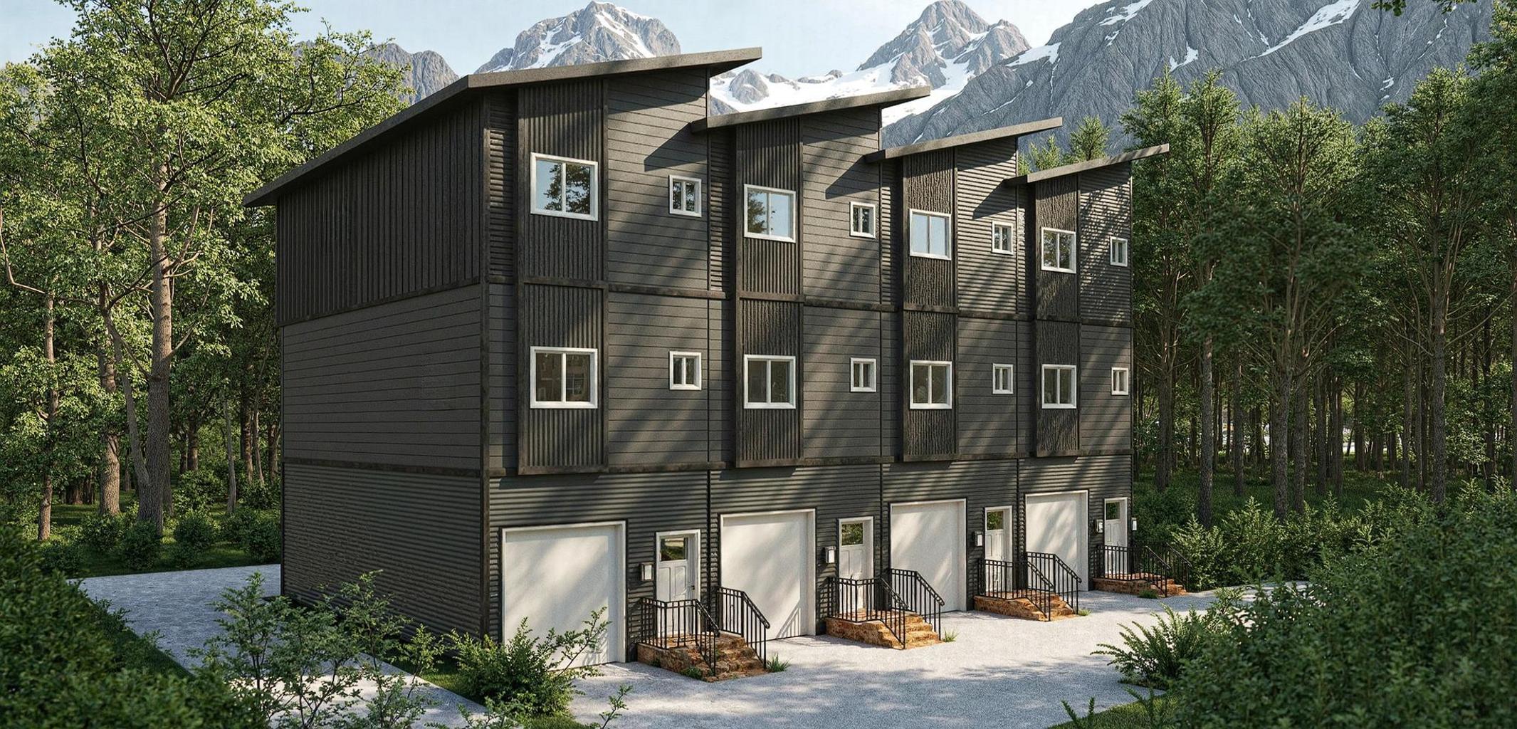 Dark multi storey modular townhouse complex against mountain peaks